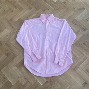 Ralph Lauren skjorta - Säljer nu denna rosa Ralph Lauren skjorta som är perfekt till sommaren! Skicket är perfekt på skjortan och det finns inga tecken på användning förutom på lappen på sista bilden. Nypris kostar skjortan 1800kr, mitt pris 400 