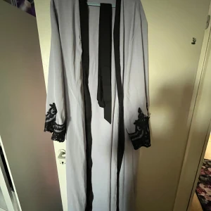 En Abaya - En blå abaya som har spets på armarna och på botten. Den har även ett svart bälte. Den e använd ba 1 gång efter jag köpte den XL men den kan användas som L också. Den är en lite mer tjockare typ av chiffong. Priset kan diskuteras. 