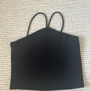 Svart topp - Cool topp från Gina i skönt material. Använts en del gånger men är fortfarande i fint skick. Säljer då jag inte längre använder den. Storlek L men sitter mer som M. 