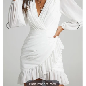 Vit klänning - Vit sommrig klänning i nyskick från Showpo. Vita volanger och långärmad, väldigt sval men ej genomskinlig. Klänningen är aldrig använd, tyvärr fel storlek. Nypris ca 1000kr.