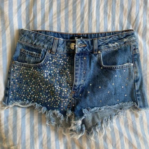 low waisted jeans shorts - Blåa jeans shorts med färgglada paljetter.