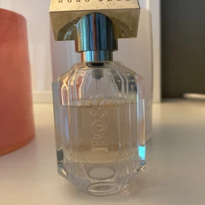Hugo Boss The Scent - Hugo Boss The Scent for her 30ml, ca 70% kvar i flaskan.   Boss The Scent For Her är en saftig och elegant parfym med noter av persika kombinerat med blomstrande fresia. Dofthjärtat är fyllt av på osmanthus, en syren känd för sin söta aprikosdoft. 