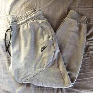 Nike tech fleece byxor - Ett par gråa nike tech byxor i nyskick. Storlek L men passar även m. Använda ca 3-4 gånger och är köpta ifrån Nikes hemsida. Säljer dom då jag ej använder dom. Hör av er vid frågor eller köp:)