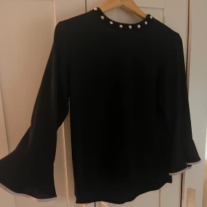 Blus  - En super söt svart tunn luftig blus med fina pärldetaljer vid kragen och utsvängda armar. Tyvärr kommer den inte till användning längre!💗