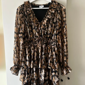 Volangklänning från vero moda - Brun svart klänning från vero moda, aldrig använd