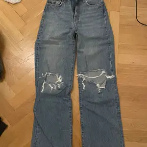 Baggy jeans men stora hål på knäna
