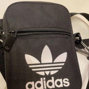 Adidas becknarväska/axelväska  - Köpt från adidas hemsida. Aldrig använd. Passar alla, barn till vuxna. 