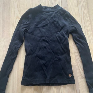 Svart polo - Svart tröja med liten polo och i ribbat tyg. Från kappahl i barn storlek, men passar även xs
