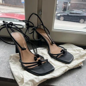 Flattered skor  - Ett par klackskor som man knyter runt ankeln från Flattered.  Använda vid ett tillfälle.   Jättefina till både klänning och till vardags under sommaren. 