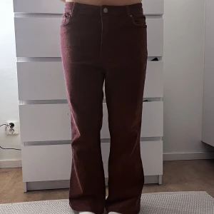 Lågmidjade byxor  - Supercoola Lågmidjade Manchester byxor i vinrött. 