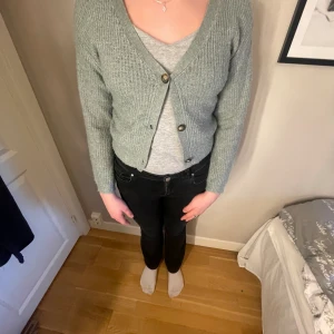 Stickad tröja  - En grön stickad tröja med knappar använd en gång 