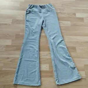 Grå Flared leggings/byxor för tjejer! Trendiga med grå tunn leggings material. I bra nytt skick. Storlek: XS  (Säljs för att de passar ej!) 