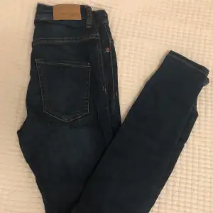 Mörkblåa tighta jeans från ginatricot i modellen MOLLY. Sparsamt använda. Väldigt stretchiga. Hög midja. Den bruna lappen i bak har en liten spricka.