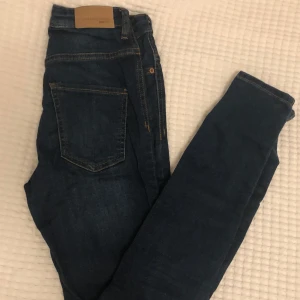 Jeans  - Mörkblåa tighta jeans från ginatricot i modellen MOLLY. Sparsamt använda. Väldigt stretchiga. Hög midja. Den bruna lappen i bak har en liten spricka.
