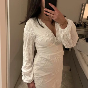 Studentklänning  - Vit klänning med broderade blommor på i storlek S, klänningen är i nyskick, bara använd på utspringet! Den är från Lindex, helt slutsåld Nypris: 699kr