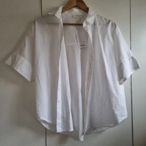 Vit Skjorta från Monki - Helt ny vit kortärmad skorta från monki. Lappen är fortfarande kvar💓 Säljer för 100kr + frakt. Vid snabb affär kan priser diskuteras🩷 