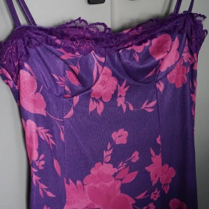 Långklänning blommig - Åtsittande och smickrande långklänning med fina detaljer i ryggen.