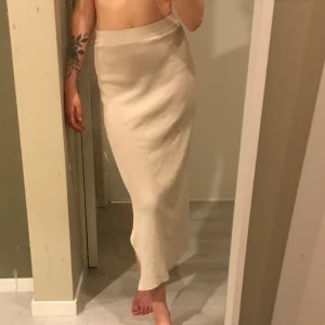 Ribbad kjol med slits  - En beige, ribbad kjol med slits! Bra kvalitet och den är i Onesize! Väldigt stretchig! 