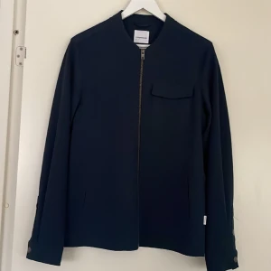 Tunn jacka från Lindbergh - Tunn jacka från Lindberg i mycket bra skick, i storlek medium. Passar bra att ha inomhus på vintern men även utomhus på våren/sommaren.