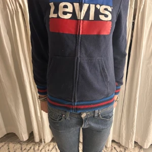 Levis hoodie - Säljer denna jätte fina levis tröjan pga att jag har växt ur den. Har någon fläck därför det billiga priset, har även en luva och fina detaljer där nere som ni kan se på första bilden.