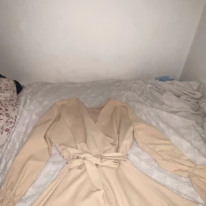 Gullig kort dress M - Säljer en gullig kort dress storlek M funkar även till S. Dressen har inte varit använd många gånger och är i färgen beige :)