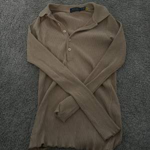 En Polo Ralph Lauren tröja med krage och knappar, sitter croppad och väldigt tajt på mig, därav säljer jag den. Mycket fint skick, inte använd på ca 2 år. 