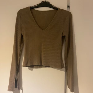 Topp - Beige/brun topp med vringning och slits vid armen. Nyskick. 
