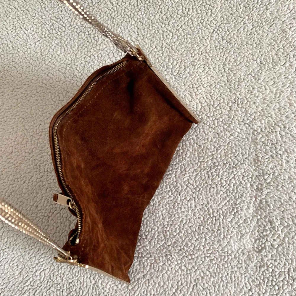 Otroligt snygg brun väska i koläder med guldiga skivor på sidorna och en nätt guldig kedja från Massimo Dutti. Väldigt vacker och rymmer allt man kan tänkas behöva. Skrivorna är något repiga, men det syns inte vid användning.. Väskor.