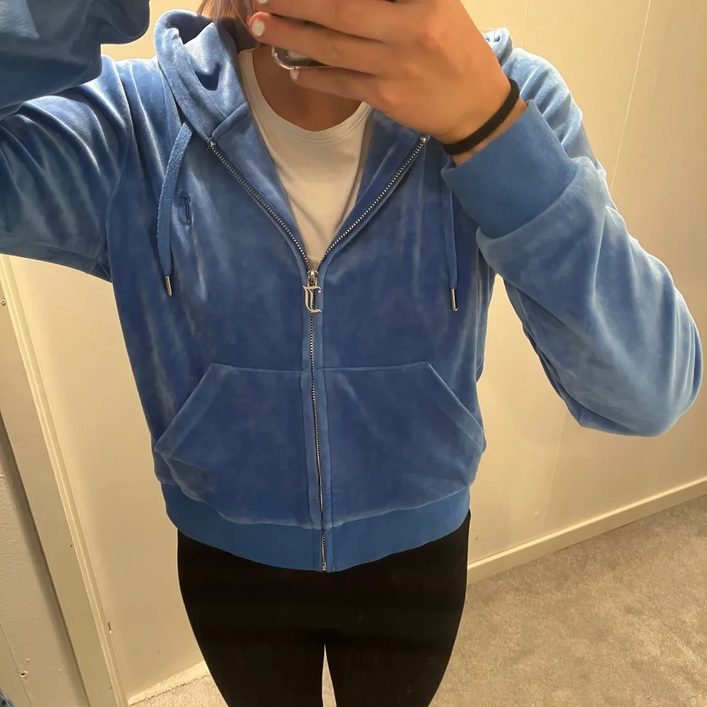 Säljer den här blåa Juicy Couture zip hoodien då den inte kommer till användning längre och bara ligger i min garderob, så skönt material och sitter verkligen perfekt😍Storleken är L men sitter som M och S skulle jag säga! jättebra skick🥰. Hoodies.