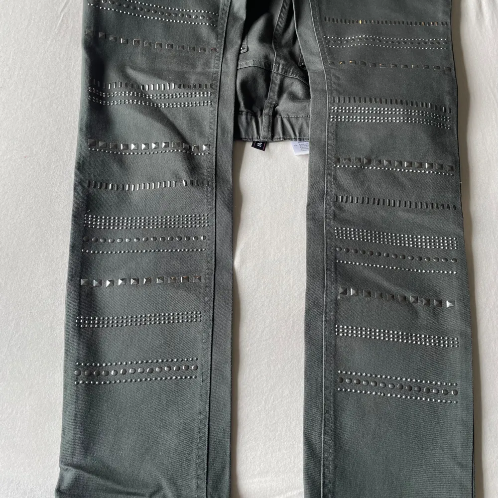 Grå byxor / leggings med nitar på framsidan och resår i midjan   Finns i Fredhäll. Jeans & Byxor.