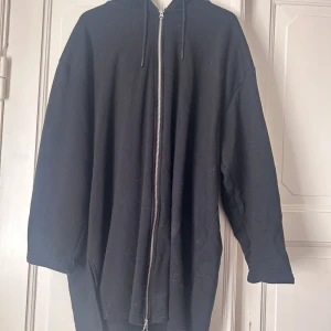 Tjocktröja  - Lång oversized kofta med dragkedja, inga fickor.