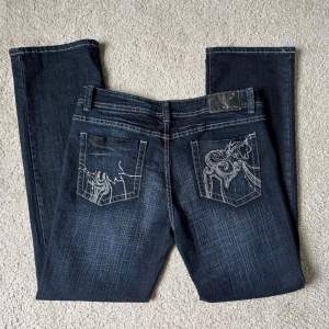 Unika mörkblå jeans med broderade fickor och detaljer. Väldigt fint skick. Storlek runt s-m skriv för mått. Har en traight/lite utsvängd passform💫