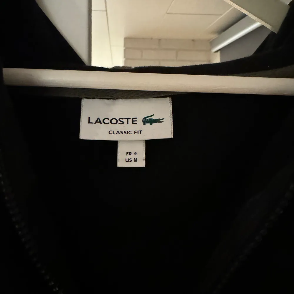 Svart lacoste hoodie använd 1-2 gånger, storlek M.. Hoodies.