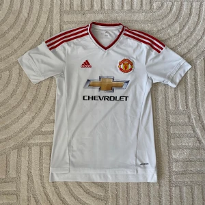 MANCHESTER UNITED FOTBOLLSTRÖJA  - ORIGINAL MANCHESTER UNITED BORTA/ 2015-2016  STORLEK: S PRIS: 249 SEK   (defekter på sponsorn förekommer)  OBS! Produkten stryks innan den fraktas iväg. Vid köp eller funderingar kontakta oss.   Instagram: @beyondthekits EJ REPLIKA #mufc#adidas