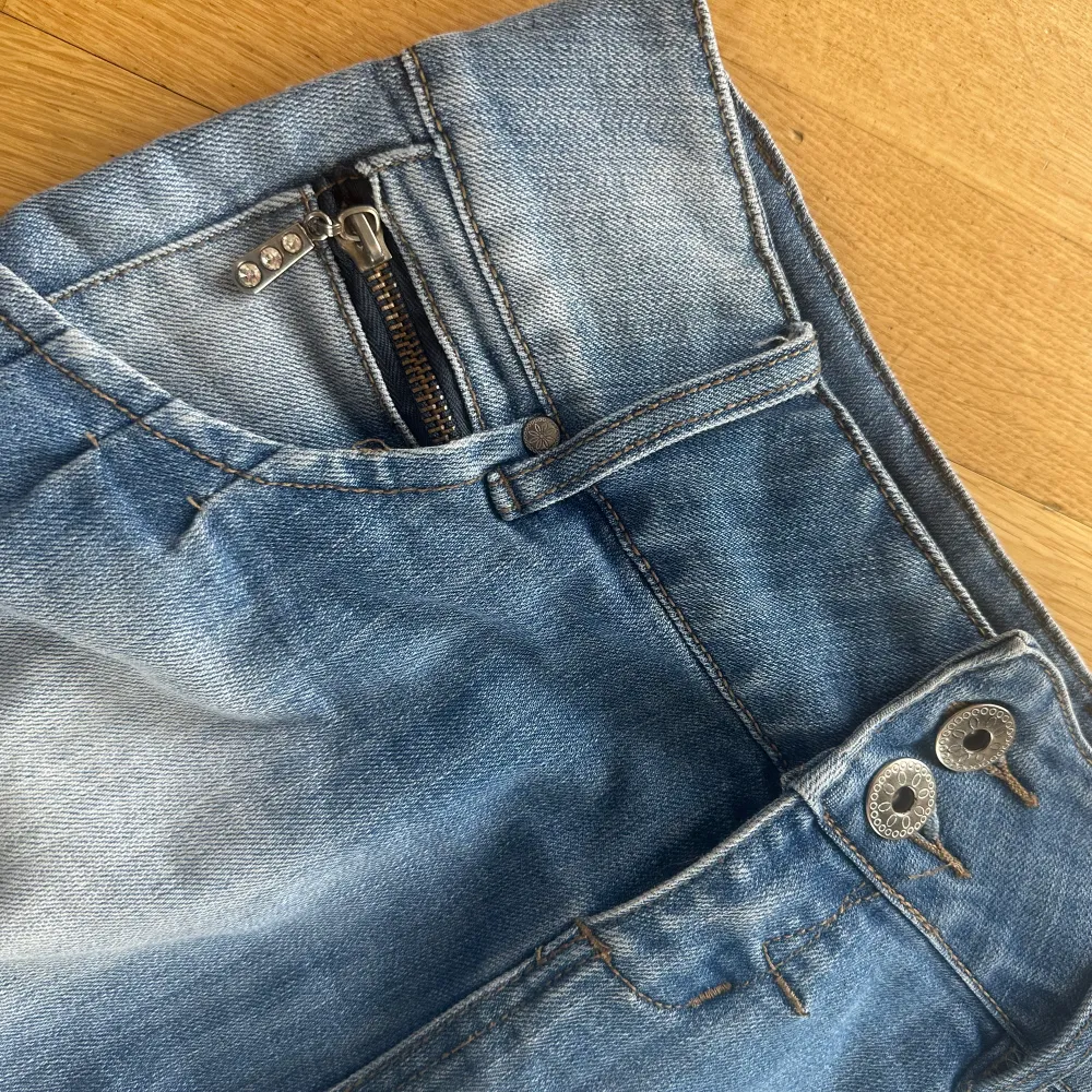 Säljer denna super söta jeans mini kjolen men snygga detaljer pga att den tyvärr var förstor för mig💕 Den är i ett super fint skick med midjemått ca 39 cm☺️  Bara att höra av sig vid frågor osv!!💗. Kjolar.
