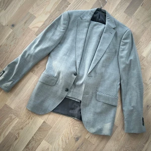 Kostym  - Grå kostym från Riley. Kavaj i storlek 46 och kostymbyxor i storlek 44. Kostymen är använd fåtal gånger och i otroligt fin skick! Meddela för fler bilder eller vid funderingar ✨