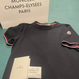 Moncler tshirt - Hej, jag säljer nu min moncler tshirt i st xs i en navy färg med märket på armen! Den är i väldigt fint skick och är köpt i Paris på Champs-Élysées! Allt og finns kvar! Hör av er vid frågor