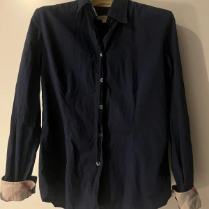 Burberry skjorta - Tjena, vi säljer nu denna feta Burberry skjorta, skick 7/10, bilder på defekterna finns på sista bilden, sitter ca 164-168, Pris ej hugget i sten, tveka inte att skriva vid någon fundering. Mvh F&J