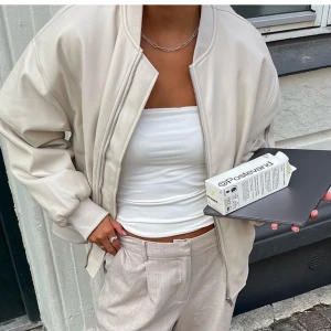 Oversized bomberjacka  - Säljer en snygg oversized bomberjacka från NA-KD i storlek 32! Gjord av PU i färgen naturvit/beige. Endast testad, prislappen är kvar! Köpt för 1099kr och säljer för 799kr.🌸