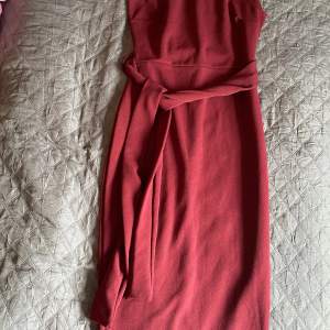 Burgundy one shoulder midiklänning med bälte i midjan. Klänningen är stretchiga. Endast använd en gång 