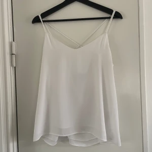 Vit blus - Jättefin vit blus med tunna band och fina detaljer i ryggen i form av ett kors