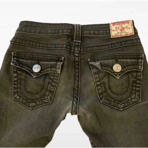 Low Waist Bootcutjeans True Religion - Gråa lowrise bootcut true religion jeans i storlek w27, väldigt bra skick! Inga hål, fläckar osv. Köpte de här på plick men de va för små, så har inte använt dom💕 midjemåttet är ungefär 40cm Pris kan diskuteras!