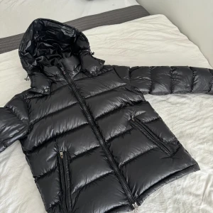 Moncler maya - Inköpt vinter 2023, skick 9/10 Size 4/ L-XL 1,83cm 84kg passar perfekt på mig Betalning sker genom Plick, men kan även mötas upp!