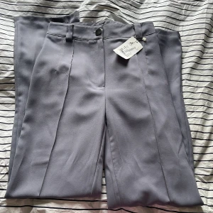 Kostymbyxa  - Säljer dessa kostymbyxor som lappen fortfarande sitter kvar på, dom är både för långa och förstora för mig, planen var att sy in dom. Byxorna är blågrå Jag är 164 cm 
