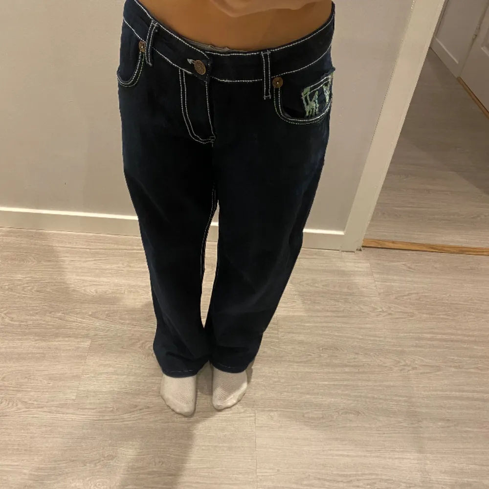 (INTE ÄKTA) säljer ett par mörkblåa med neongrön tjock stygn true religion baggy byxor. Nypris vet ej. . Jeans & Byxor.