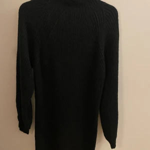 Svart stickad klänning  - Storlek 34/36. Slutar mitt på låret. 