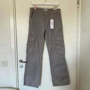 Low waist cargo jeans - Superfina och trendiga low waist cargo byxor i ljusgrå färg! Sjukt fint till alla årstider😍Aldrig använt och därav i perfekt skick. Prislappen finns kvar. Storlek 36💗obs; står inte för frakt!