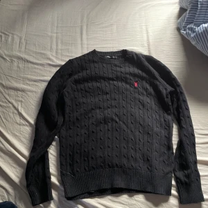 Stickad kabel tröja - Säljer min stickade kabel tröja som är lik polo Ralf lauren. Är i bra skick och inga skador 🌟Pris kan diskuteras 