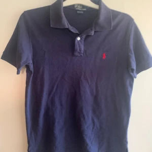 Ralph Lauren piké - En perfekt marinblå Ralph Lauren piké inför sommaren. Skicket är 8/10 och kostar cirka 1000kr nytt pris min kommer att säljas för 299!!! Skriv till mig om du har frågor!