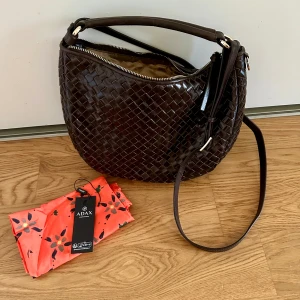 Adax salerno shoulder bag marlin, mörkbrun - Säljer en helt ny (fick hem den häromdagen) Adax axelremsväska, i färgen mörkbrun. Själva väskan och modellen är superfin, det är bara jag som trodde jag beställt en svart väska och inser att brun inte är min färg. Nypris; 3099kr Mått; 22*31*8 cm